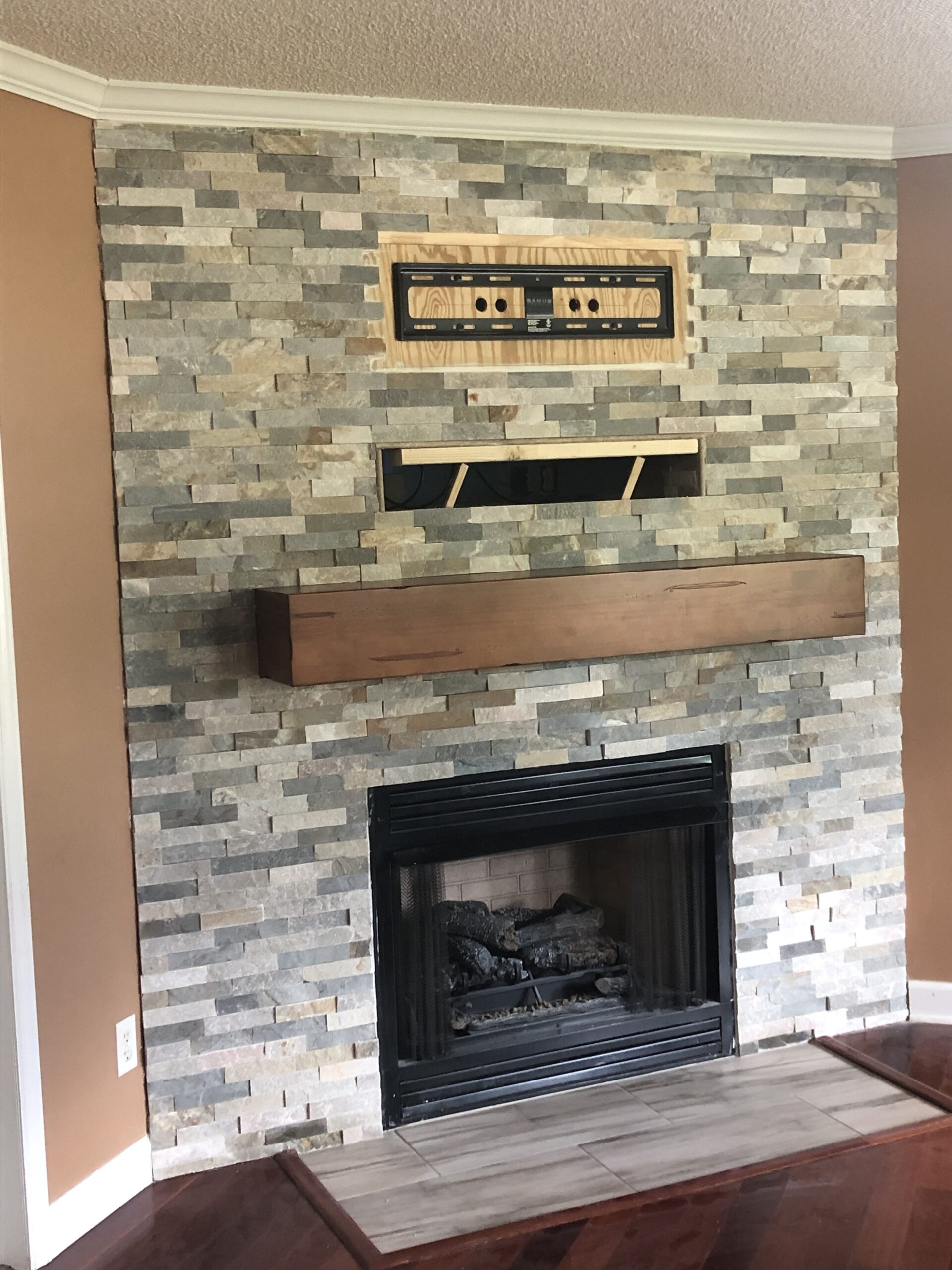 fascinating tv bracket installed &amp; rest of wall stoned | stone fireplace wall how to stack wood in fireplace photo